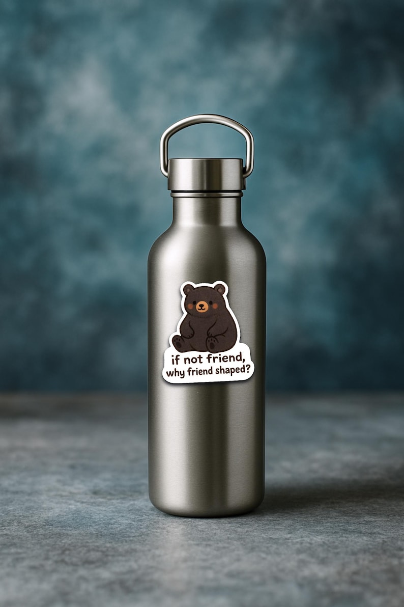 May include: A stainless steel water bottle with a silver handle. A sticker of a cartoon bear with the text "if not friend, why friend shaped?" is affixed to the bottle. The bear is brown with a white cloud-shaped background.