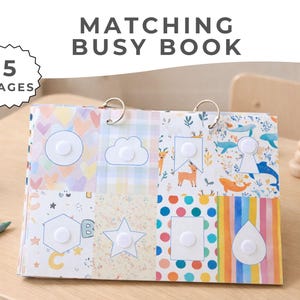 May include: A colorful "Matching Busy Book" with 5 pages, featuring various shapes and patterns. The book is bound with metal rings and includes a wooden toy and colored pencils on a light wood surface.