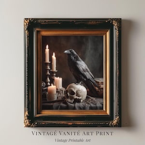 May include: Framed vintage art print featuring a black raven perched atop a human skull. The artwork includes lit candles and a dark background, all within a black and gold ornate frame. Text at the bottom reads "VINTAGE VANITÉ ART PRINT" and "Vintage Printable Art."