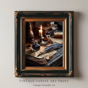 Puede incluir: Impresión artística vintage enmarcada con una pluma, un tintero y una vela encendida sobre libros antiguos. El marco es negro con detalles dorados. El texto "VINTAGE VANITÉ ART PRINT" y "Vintage Printable Art" está en la parte inferior.