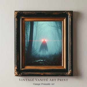 May include: Framed art print featuring a surreal forest scene with a silhouetted figure with glowing red eyes. The artwork is set in a misty, dark forest, with the text "VINTAGE VANITÉ ART PRINT" and "Vintage Printable Art" at the bottom.