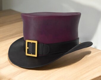 May include: A purple top hat with a black brim and band. The hat features a gold-colored buckle on the band. The hat is sitting on a light brown wooden surface.
