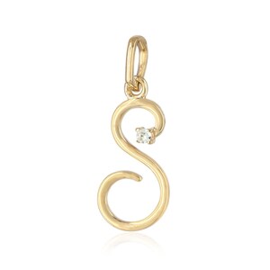 May include: A gold-coloured pendant in the shape of the letter "S". The pendant has a small, clear gemstone and a loop for a chain. The design is elegant and minimalist, suitable for everyday wear.