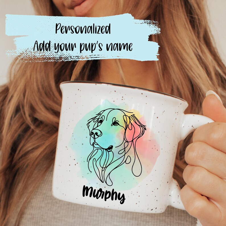 Puede incluir: Taza de cer&aacute;mica blanca moteada con un dibujo lineal de la cara de un perro y un fondo de acuarela colorido. La taza est&aacute; personalizada con el nombre "Murphy" y el texto "Personalized Add your pup's name".