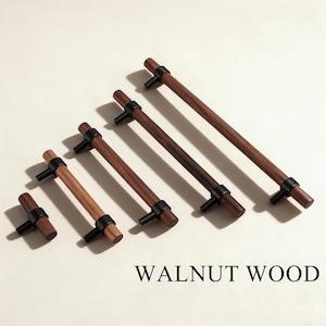 Może przedstawiać: Kolekcja uchwytów do szafek z drewna orzechowego w różnych rozmiarach. Każdy uchwyt ma ciemnobrązowy drewniany uchwyt z czarnymi metalowymi akcentami. Tekst "WALNUT WOOD" jest wyświetlany na dole obrazu.