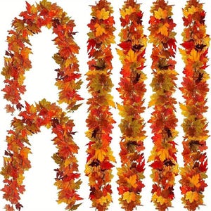 May include: Artificial fall leaf garlands in shades of red, orange, and yellow. The garlands are arranged in a decorative display, perfect for autumn-themed decor. The leaves are detailed and realistic, creating a festive atmosphere.