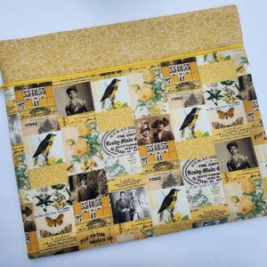 May include: A rectangular zippered pouch featuring a collage print of vintage photographs, yellow roses, songbirds, and text including "Strauss Ready-Made" and "London". The top section is a solid yellow fabric with a subtle tonal pattern.