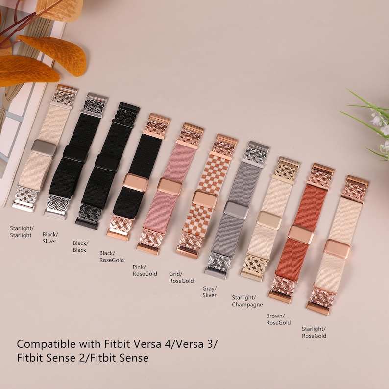 K&ouml;nnte beinhalten: Eine Auswahl an elastischen Uhrenarmb&auml;ndern in verschiedenen Farben, darunter Schwarz, Rosa, Grau und Beige. Jedes Band hat einen Metallverschluss und -anschluss in Silber oder Ros&eacute;gold. F&uuml;r Fitbit Versa und Sense.
