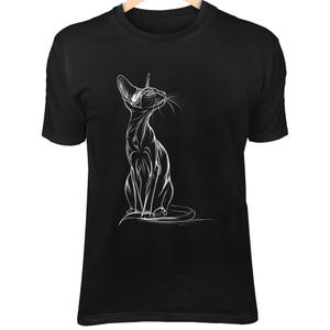 May include: Black t-shirt featuring a white line drawing of a slender cat in a seated position, looking upwards. The cat's ears are large and pointed, with long whiskers. The design is centered on the shirt.