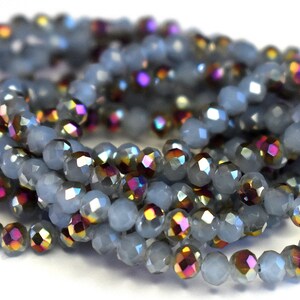May include: A strand of light blue faceted glass beads with iridescent accents. The beads are small and round, and they are strung together on a clear thread.