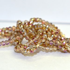 May include: A strand of iridescent gold glass beads, perfect for jewelry making or crafting projects.