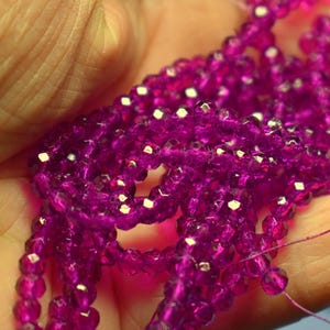 May include: A strand of faceted purple glass beads. The beads are small and have a shiny finish.