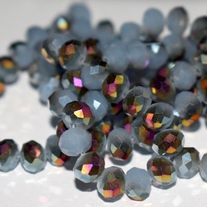 May include: A strand of iridescent gray and clear glass beads. The beads are faceted and have a subtle shimmer.