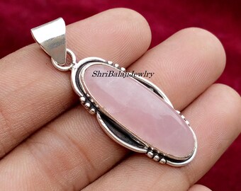 May include: Oval-shaped rose quartz pendant with a silver bail. The pendant has a light pink gemstone set in a silver frame with a beaded edge. The text "ShriBalajiJewlry" is visible on the pendant.