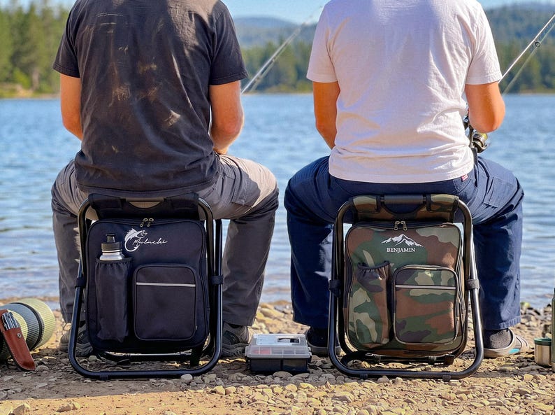 May include: Two portable folding stool backpacks with integrated storage compartments. One is solid black with a white fish logo and the name "Mulnaki," while the other features a green camouflage pattern with a mountain logo and the name "Benjamin."