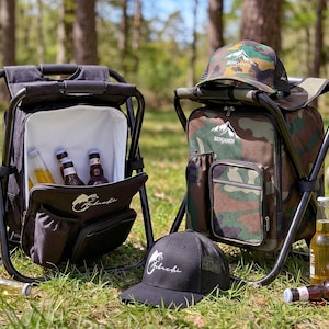 May include: Two portable folding stool backpacks, one solid black and one camouflage print, each featuring a white interior cooler compartment. The black bag displays a fish logo, while the camouflage bag features a mountain logo and matching cap.