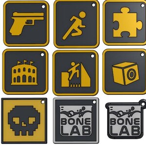 Könnte beinhalten: Eine Sammlung quadratischer, schwarz-goldener Anstecknadeln mit verschiedenen grafischen Designs. Die Designs umfassen eine Leiter, eine Pistole, eine laufende Figur, ein Puzzleteil und den Text "BONE LAB". Jede Nadel hat ein kleines Loch oben.