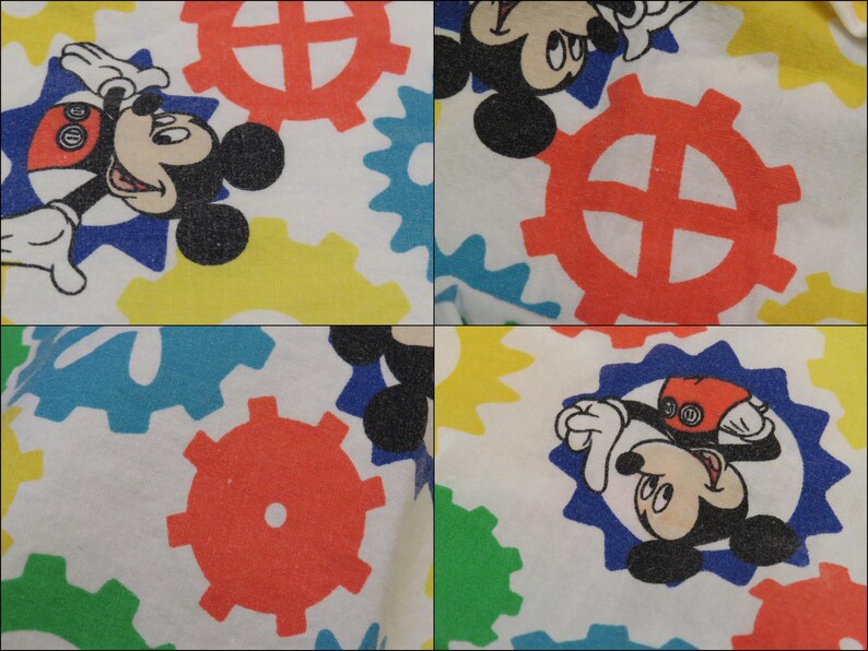 May include: White fabric with a repeating pattern of Mickey Mouse and colourful cogs. Mickey Mouse is shown in different poses within blue starburst shapes. The cogs are red, yellow, blue, and green.