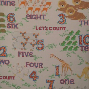 May include: A white fabric with colorful illustrations of animals and numbers. The numbers one through ten are displayed with corresponding animal groups, such as lions, sheep, and rabbits. The words for each number are also written out.