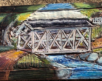 An engraved wood relief - "Criss Cross Covered Bridge"  - An example of a historical site - a covered bridge made for crossing over water.