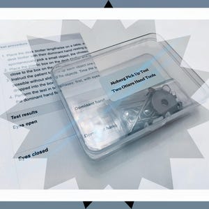 May include: A clear plastic container holding small metal tools and hardware. The label reads "Moberg Pick Up Test Two Otters Hand Toolz." A printed sheet with test instructions and results is visible.