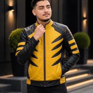 May include: A black and yellow leather jacket with a zip-up front. The jacket has black sleeves and shoulders, with yellow panels on the front and arms. The yellow panels have black claw-like stripes. The jacket is worn with black trousers.