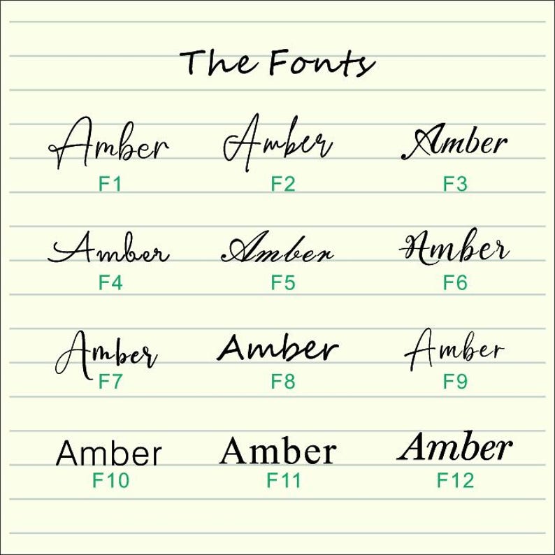 Peut inclure: Une page manuscrite avec le titre "The Fonts". Douze variations du mot "Amber" sont pr&eacute;sent&eacute;es, chacune avec un num&eacute;ro de F1 &agrave; F12, illustrant diff&eacute;rents styles de police sur un fond lign&eacute;.