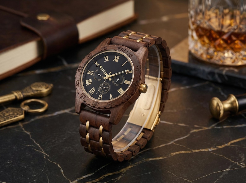 Peut inclure: Une montre-bracelet en bois avec un cadran sombre et des aiguilles et des accents dor&eacute;s. La montre a un bracelet en bois marron avec des maillons dor&eacute;s. Le cadran de la montre comporte des chiffres romains. La montre est pr&eacute;sent&eacute;e sur une surface sombre.