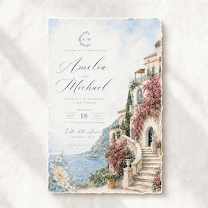 May include: A rectangular wedding invitation card with deckled edges featuring a watercolor illustration of a coastal villa in Positano, Italy. The text reads: Together with their families, Amelia and Michael invite you to celebrate their wedding, Saturday, May 18, 2026, at a o'clock in the afternoon, Villa delle Sirene, Positano, Italy, reception to follow.