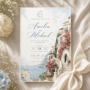 May include: A rectangular wedding invitation card featuring a watercolor illustration of a coastal Italian villa with pink bougainvillea, stone stairs, and a sea view. The text reads: Together with their families, Amelia and Michael, invite you to celebrate their wedding, Saturday, May 18, 2026, at 4 o'clock in the afternoon, Villa delle Sirene, Positano, Italy, reception to follow.