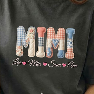 Puede incluir: Camiseta gris oscuro con la palabra "MIMI" en un diseño de patchwork. Debajo están los nombres Leo, Mia, Sam y Ava, cada uno con un símbolo de corazón. Un gato blanco está en primer plano.