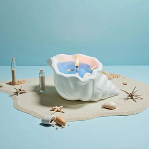 May include: A white seashell-shaped candle with a blue wax interior and a lit yellow flame. The candle is decorated with small seashells and starfish. The candle sits on a sandy surface with additional seashells and starfish.