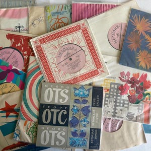 Peut inclure: Une collection de disques vinyles vintage dans des pochettes en papier présentant divers motifs graphiques, incluant des fleurs, des formes abstraites et du texte comme Georg Ots et Melodiya. Les disques sont disposés en couches superposées.