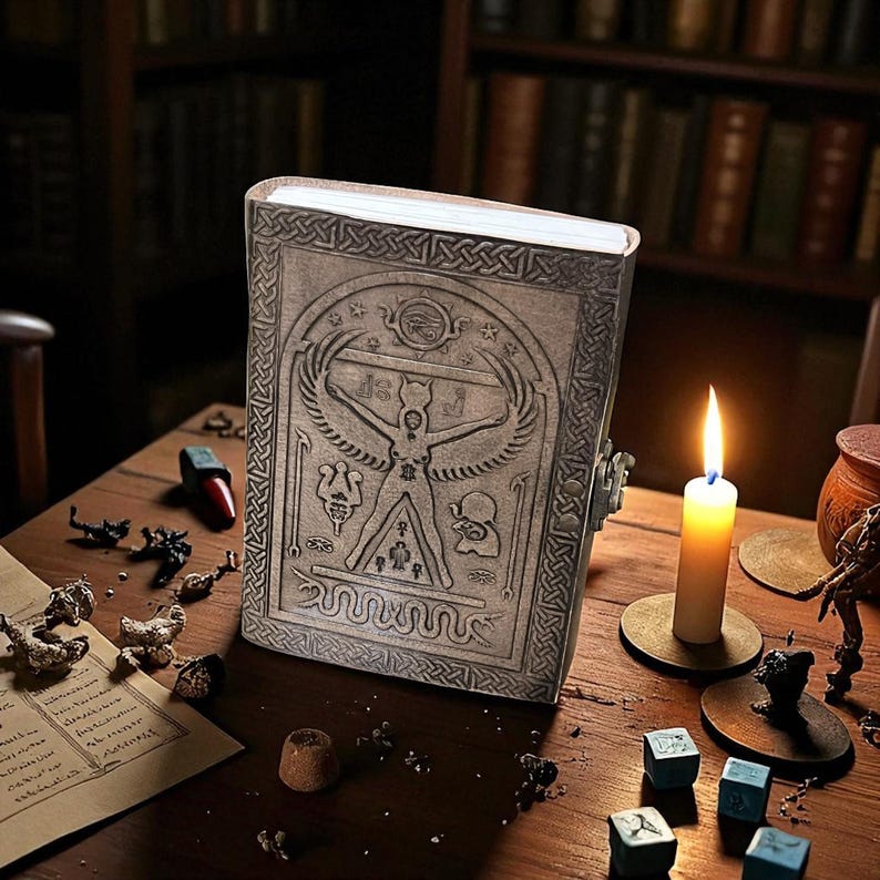 May include: A detailed, gray, embossed book with an ancient Egyptian design, featuring a winged figure and hieroglyphs. The book is on a wooden table, lit by a candle. Other items include dice, a small jar, and scattered objects.