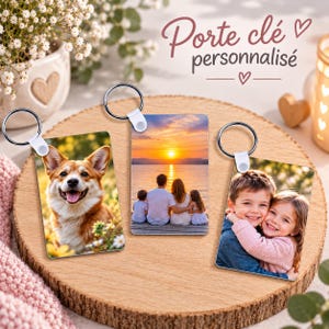 Peut inclure: Trois porte-clés rectangulaires avec anneaux métalliques, chacun présentant une photographie imprimée différente : un chien corgi, une famille regardant un coucher de soleil sur l'eau et deux enfants s'étreignant. Texte "Porte clé personnalisé".