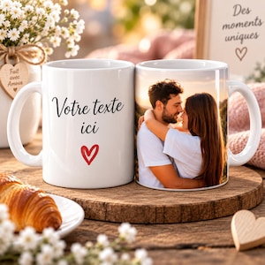 Może przedstawiać: Dwa białe ceramiczne kubki. Jeden kubek zawiera czarny napis "Votre texte ici" nad czerwonym sercem. Drugi kubek przedstawia zdjęcie pary obejmującej się na zewnątrz. Kubki umieszczone są na okrągłej drewnianej desce.