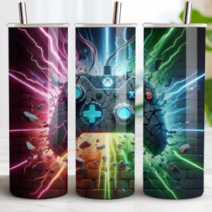 May include: Three stainless steel tumblers with a gaming theme. Each tumbler features a different design: one with red lightning, one with a controller, and one with green lightning. All designs are set against a brick wall background.