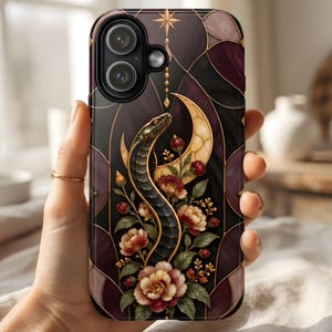 Op de afbeelding: Een smartphonehoesje met een donker ontwerp in glas-in-loodstijl, met een zwarte slang die door een crèmekleurige halve maan en bloemmotieven kronkelt. De achtergrond bestaat uit donkerpaarse en zwarte geometrische segmenten met gouden lijnen.