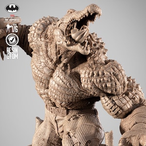 May include: A detailed statue of Killer Croc, a DC Comics character, with a textured, reptilian skin effect. The figure is in a dynamic pose, mouth open, showcasing sharp teeth. The statue is pre-supported and scaled 1/6.