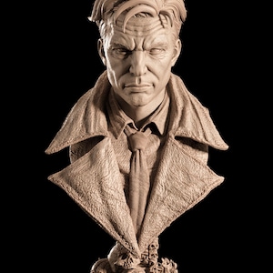 May include: A detailed bust sculpture of a man with a stern expression, wearing a coat and tie. The sculpture is a light brown color and rests on a base with skulls. The background is black.