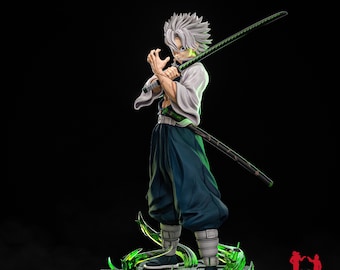 May include: A detailed figurine of a character with spiky white hair, wearing a white and blue outfit, and holding a black sword with a green edge. The figure is posed on a green, textured base. The text "1/8 SCALE" is visible.