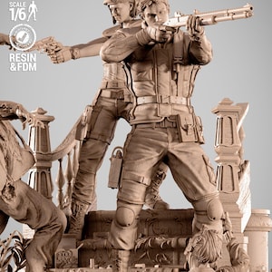 Pode incluir: Estátua de resina detalhada de duas figuras em equipamento tático, uma apontando com uma espingarda, a outra com uma pistola. A estátua é um modelo à escala 1/6, com texto indicando que é pré-suportada e testada.
