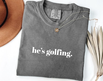 Comfort Colors® He's Golfing Shirt, Golfing Season Shirt, Golfer Wife Shirt, Golfing Mom Shirt, Golf Player Shirt for Mom, Golf Lover Shirt
