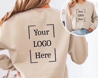 May include: Beige sweatshirt with the text "Your LOGO Here" in a black box on the front and back. The sweatshirt is a neutral color and has long sleeves. The design is simple and clean, suitable for custom branding.