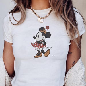 May include: A white ceramic mug with a black handle and the text "But First, Coffee" in a black, bold font. The mug is sitting on a white surface.