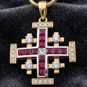 May include: A Jerusalem cross pendant crafted from yellow gold and silver, featuring a central square diamond surrounded by channel-set square rubies. The cross arms are accented with round brilliant-cut diamonds and a gold chain bail.