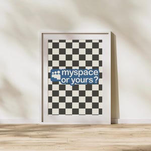May include: Framed print with a black and cream checkerboard pattern background. The print features the text "myspace or yours?" in blue and white, evoking a nostalgic internet theme. The print is displayed in a white frame.
