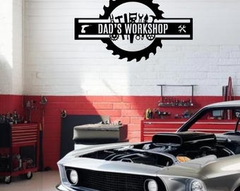 May include: Black metal sign with the text "DAD'S WORKSHOP" and various tool silhouettes. The sign is set against a white and red brick wall, with a classic silver car in the foreground.