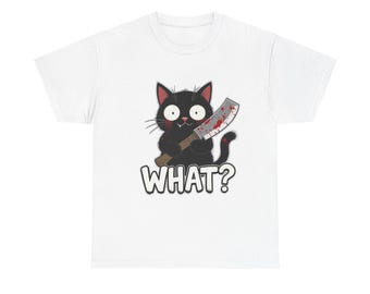 May include: White t-shirt featuring a cartoon black cat holding a bloody knife. The cat has wide eyes and the word "WHAT?" is printed below the cat in white block letters. The shirt is a casual wear item.