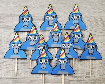 May include: Twelve blue cupcake toppers with a monkey face and a colorful party hat. Each topper has a wooden stick for inserting into a cupcake.